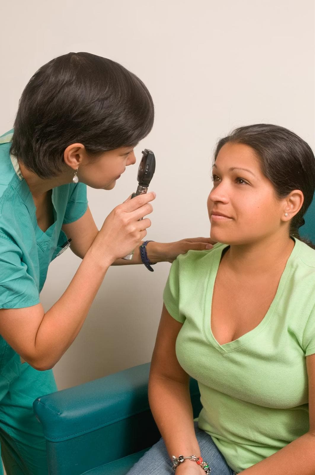 A clinician checking a patient's eyes during a routine health visit.